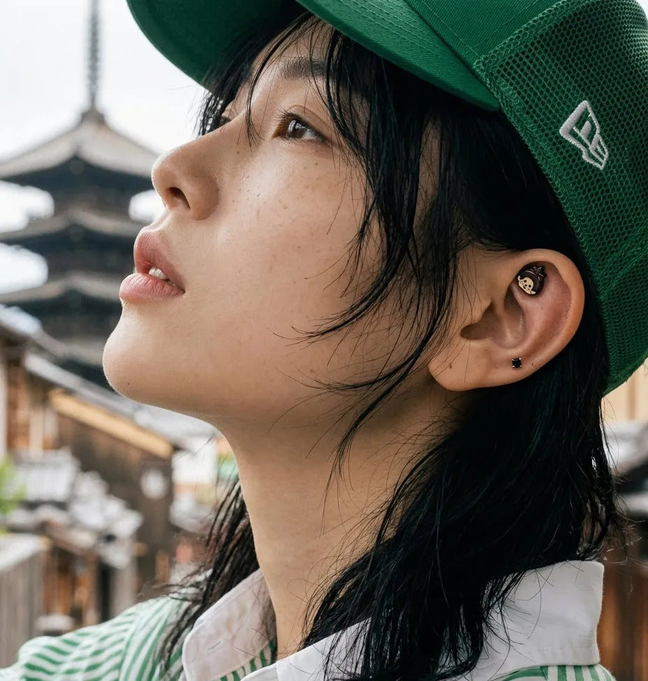 Monchhichi enamel helix stud on model wearing green New Era cap — grunge-cute K-style ear stack