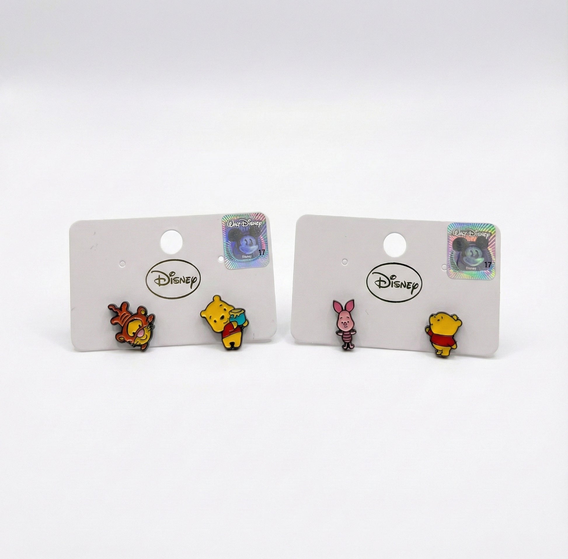 Two sets of Disney Pooh earrings side by side: Tigger with Pooh and Piglet with Pooh, mismatched design comparison