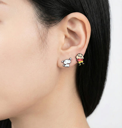 Crayon Shin-chan inspired mismatched stud earrings worn on the earlobe — a white dog figure and a child figure in a red top and yellow shorts.