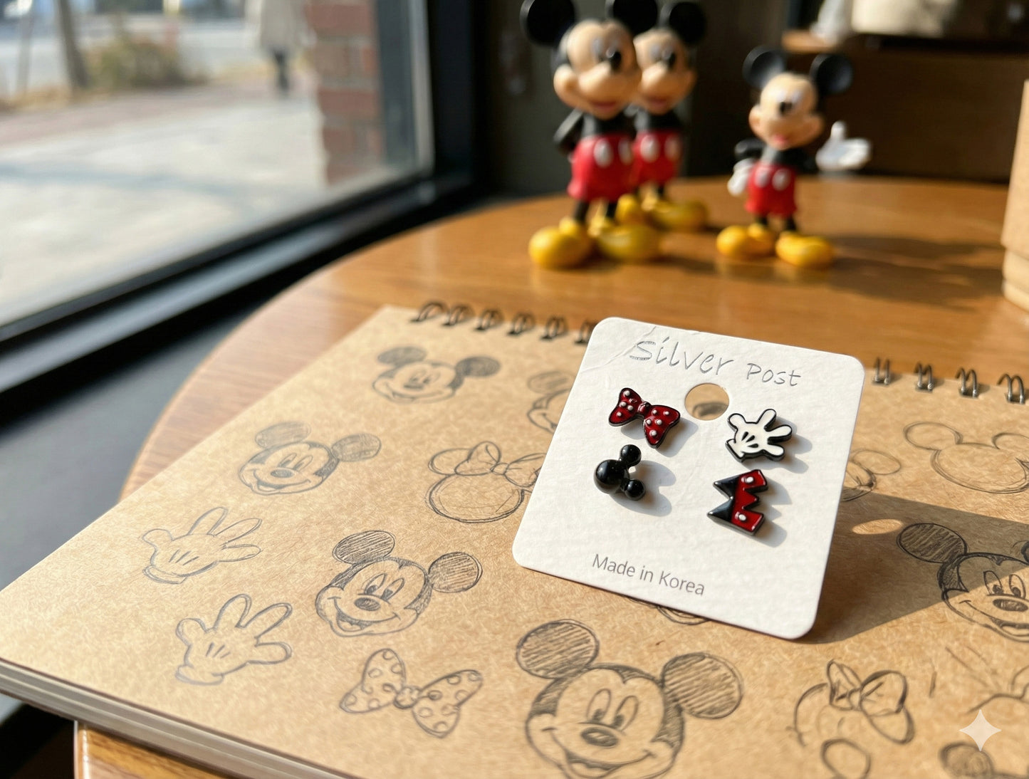 Disney Mickey Mouse 4-piece earring set displayed on white card with Mickey figurines in background showing all four designs