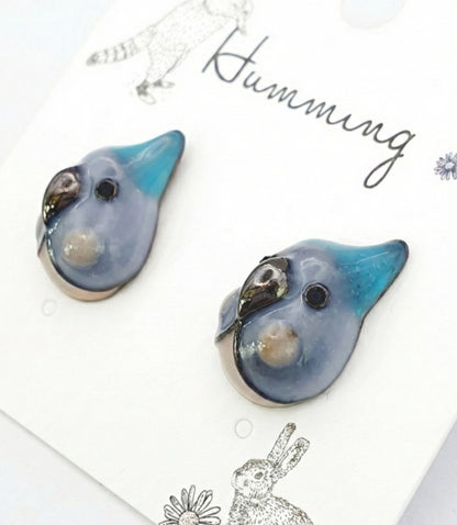  Close-up of blue parrot earring pair with teal beak and slate blue enamel glaze 