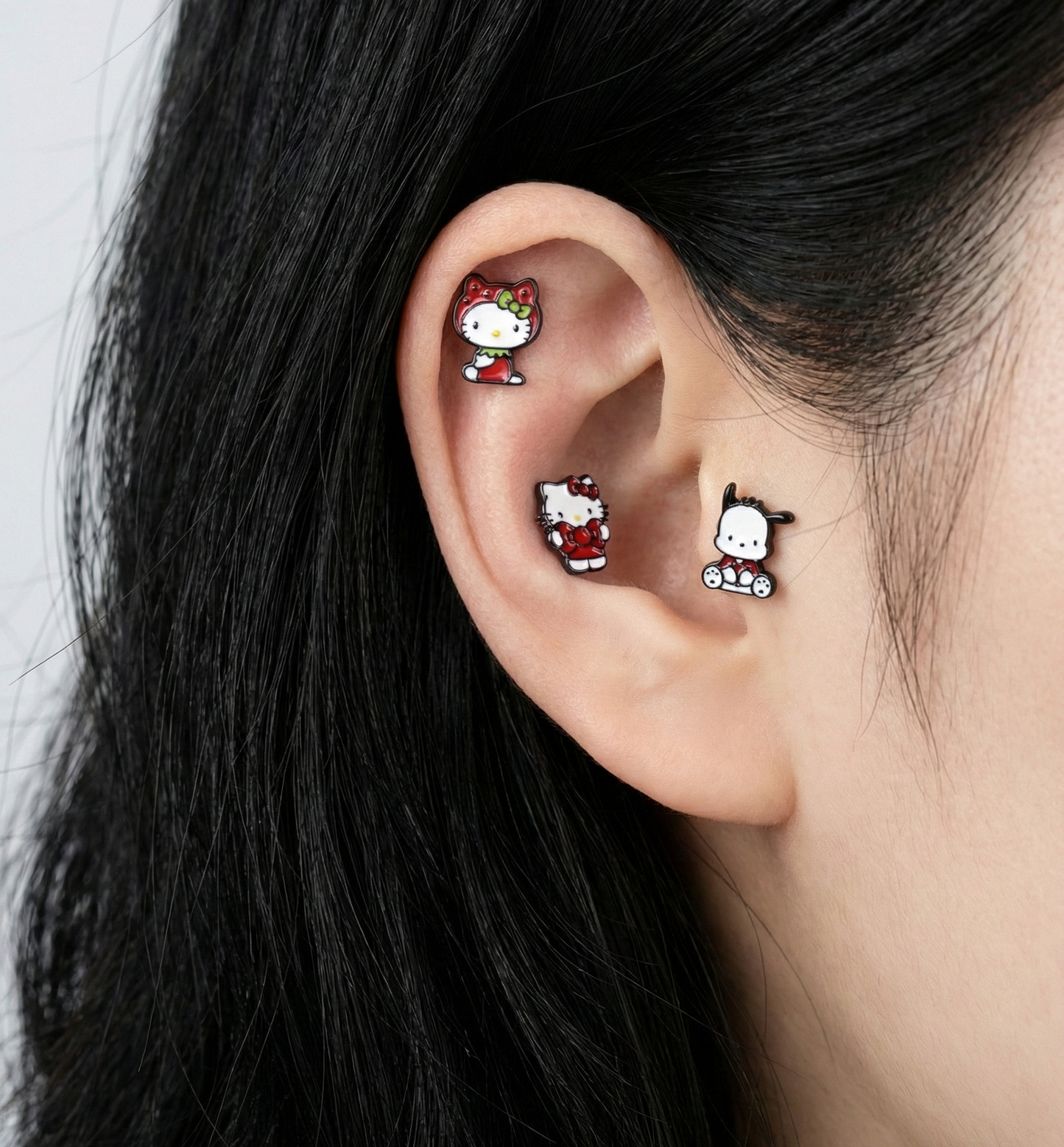 Multiple Hello Kitty and Sanrio character piercings arranged in full ear curation