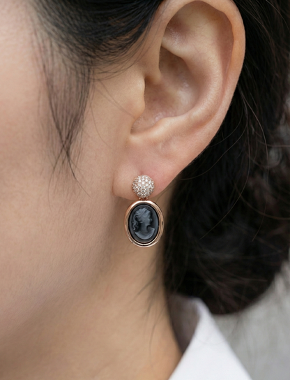 Close-up of woman wearing black vintage cameo earring with crystal stud