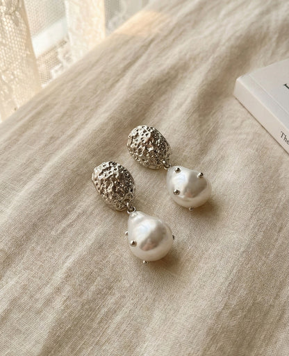  Close-up detail of silver hammered baroque pearl earrings showing texture