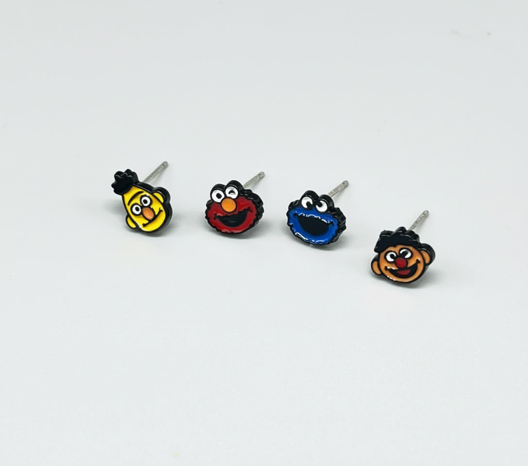 Four Sesame Street character earrings displayed individually showing Bert Elmo Cookie Monster and Ernie with 925 sterling silver posts
