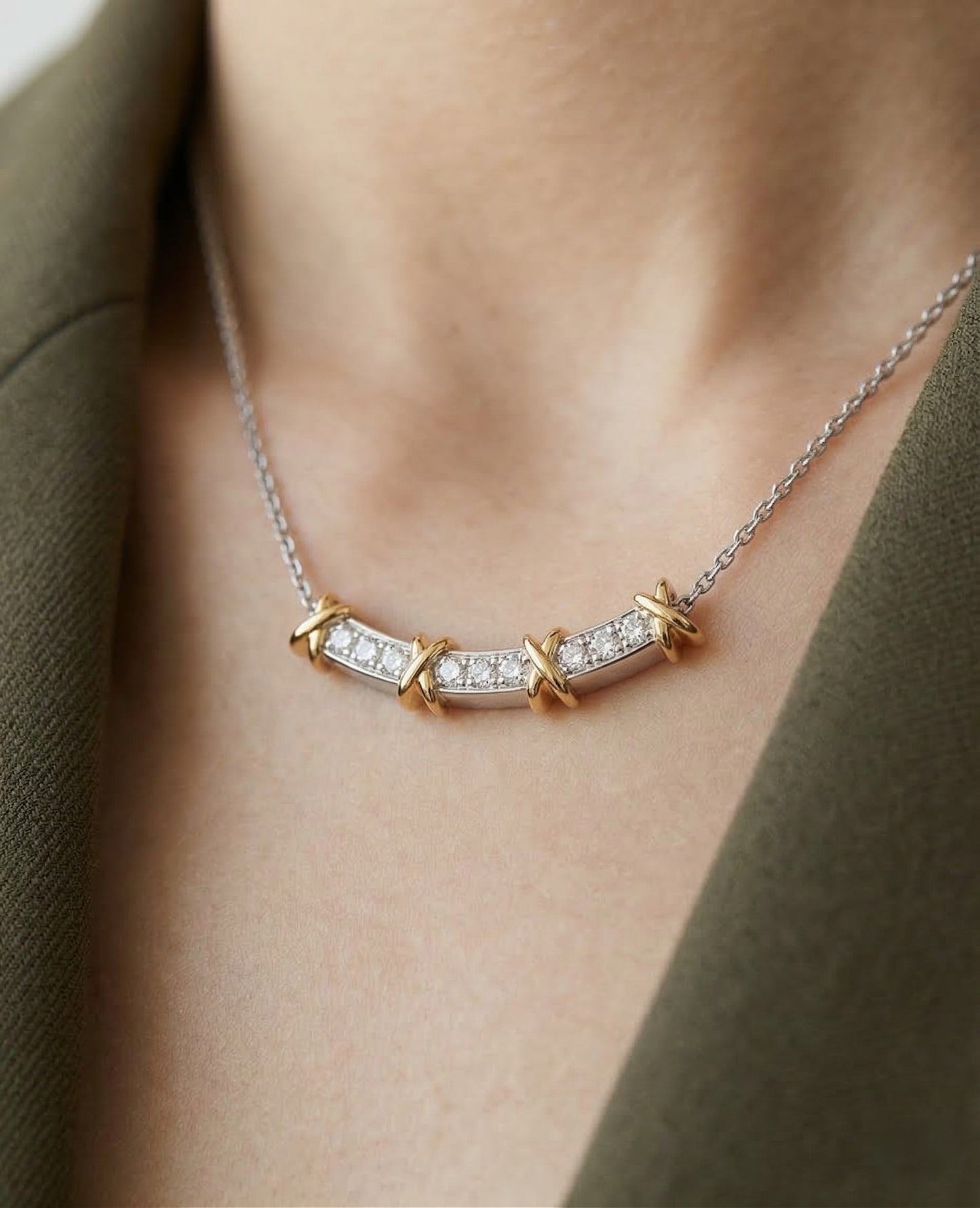 Necklace with a diamond pendant worn by a person, against a neutral background