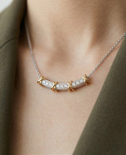 Necklace with a diamond pendant worn by a person, against a neutral background