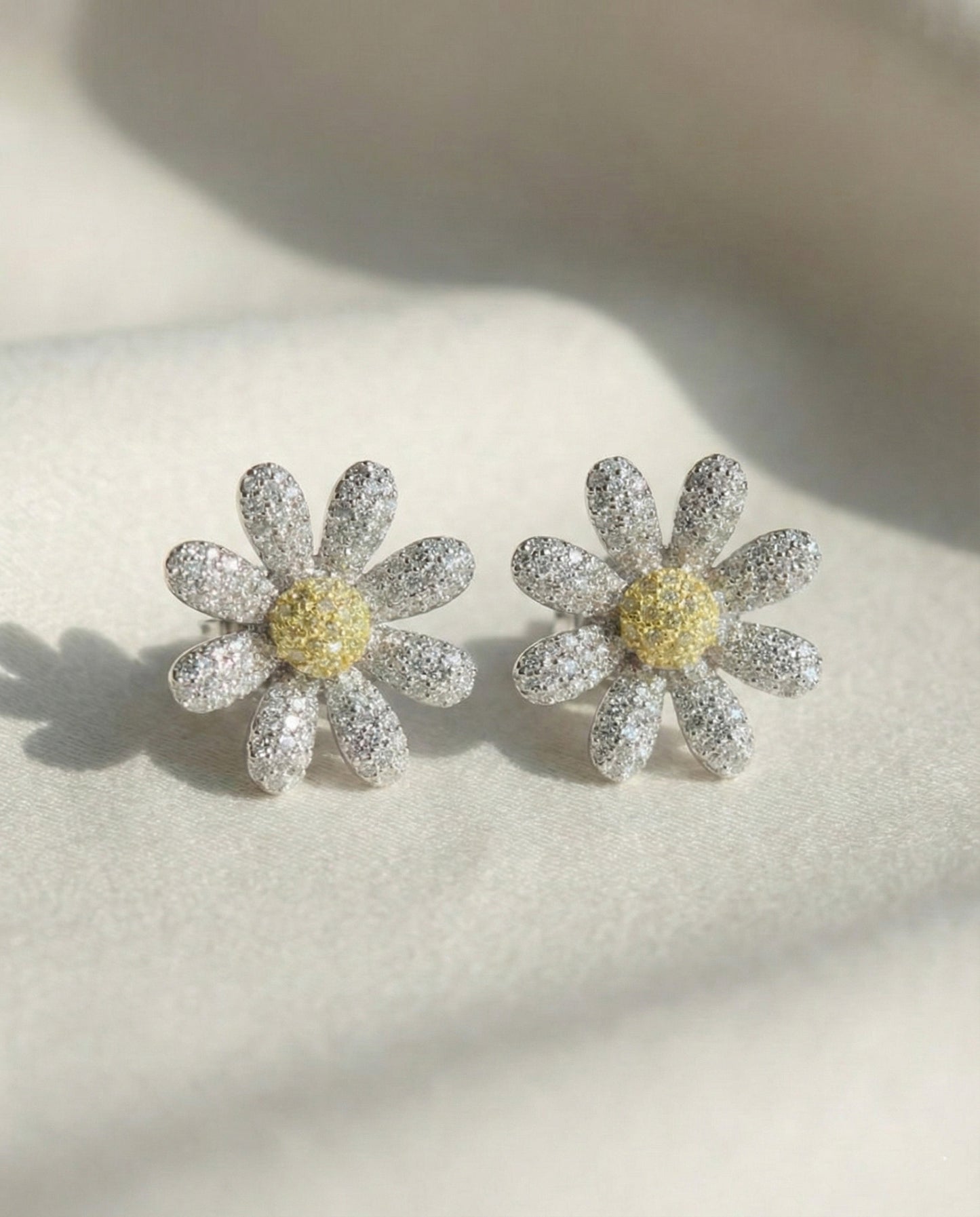 Two daisy flower earrings with yellow center cubic zirconia - front view detail shot