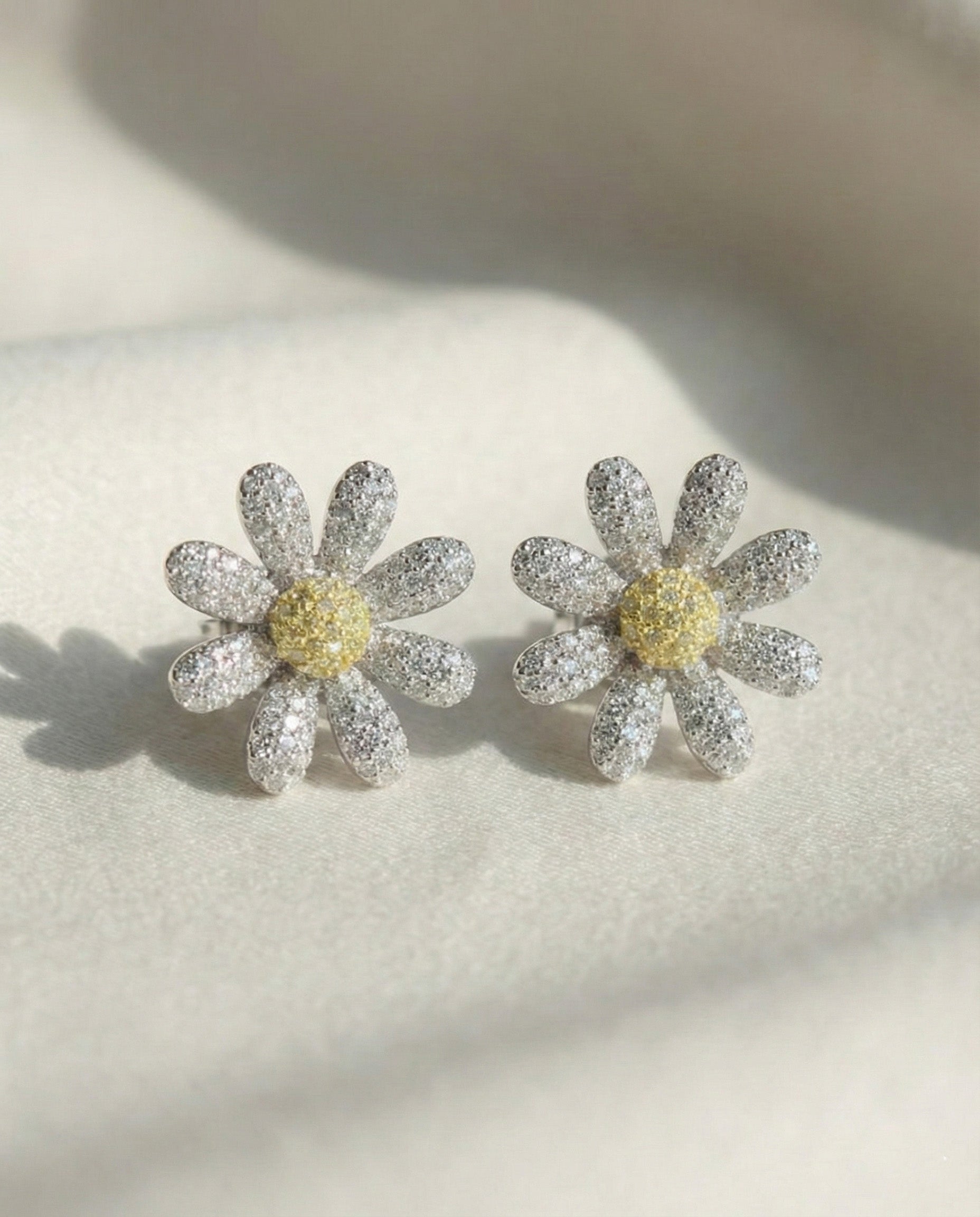 Two daisy flower earrings with yellow center cubic zirconia - front view detail shot