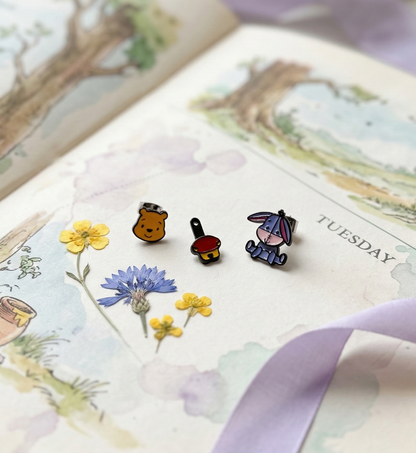 Two-way jacket earrings disassembled showing Pooh and Eeyore front studs and back body pieces