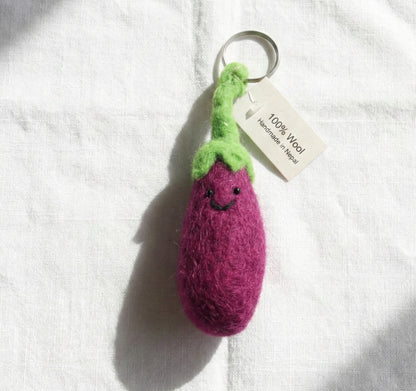 Purple eggplant felt keychain with green stem on white background