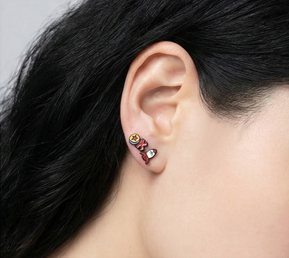 Ear closeup showing Toy Story Pixar Ball and Rocket stud earrings worn together