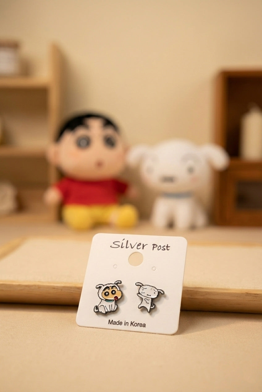 Kawaii Shin-chan Shiro earrings on natural wood tray with anime plush dolls in background