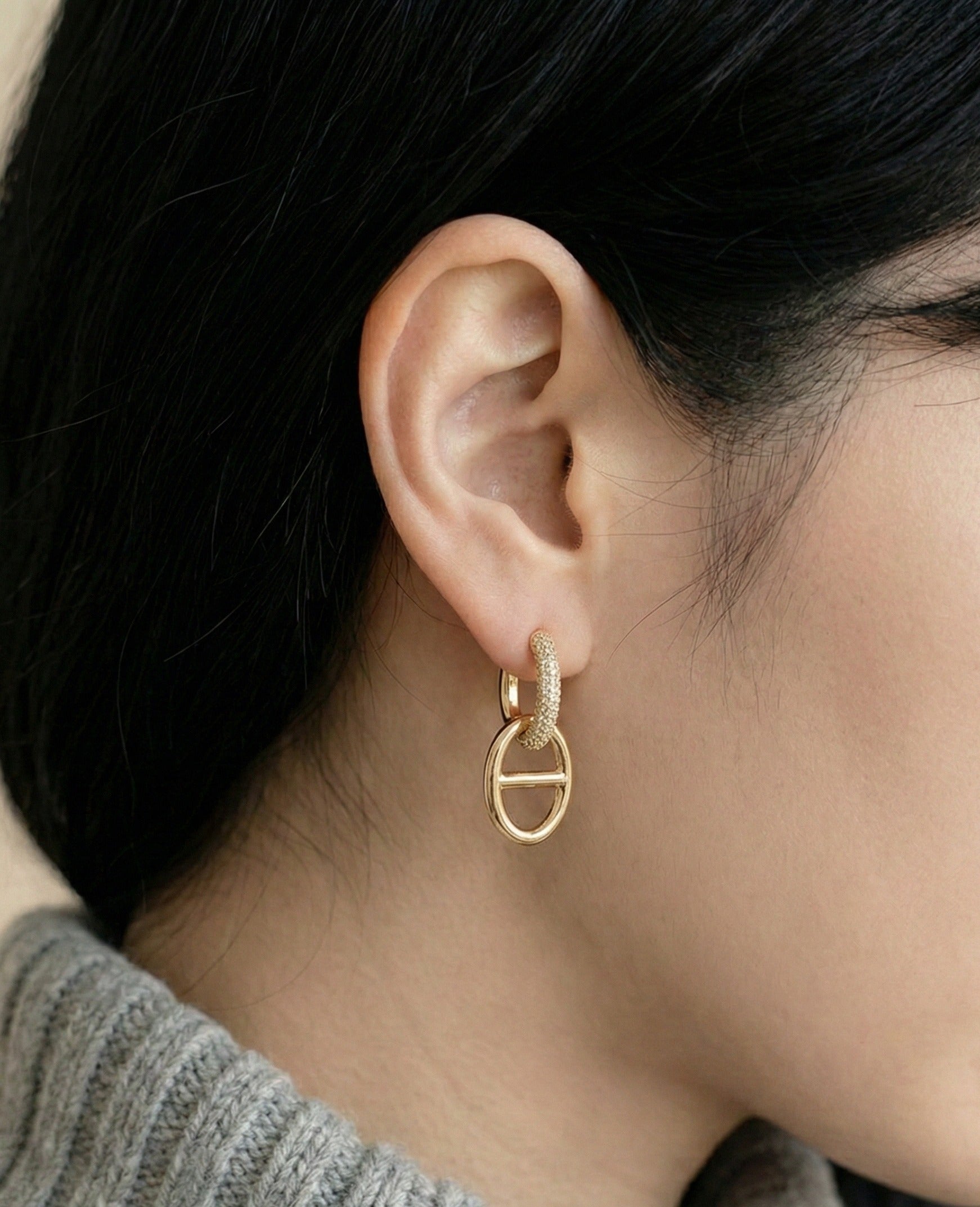 Side view of elegant anchor chain drop earrings on model ear