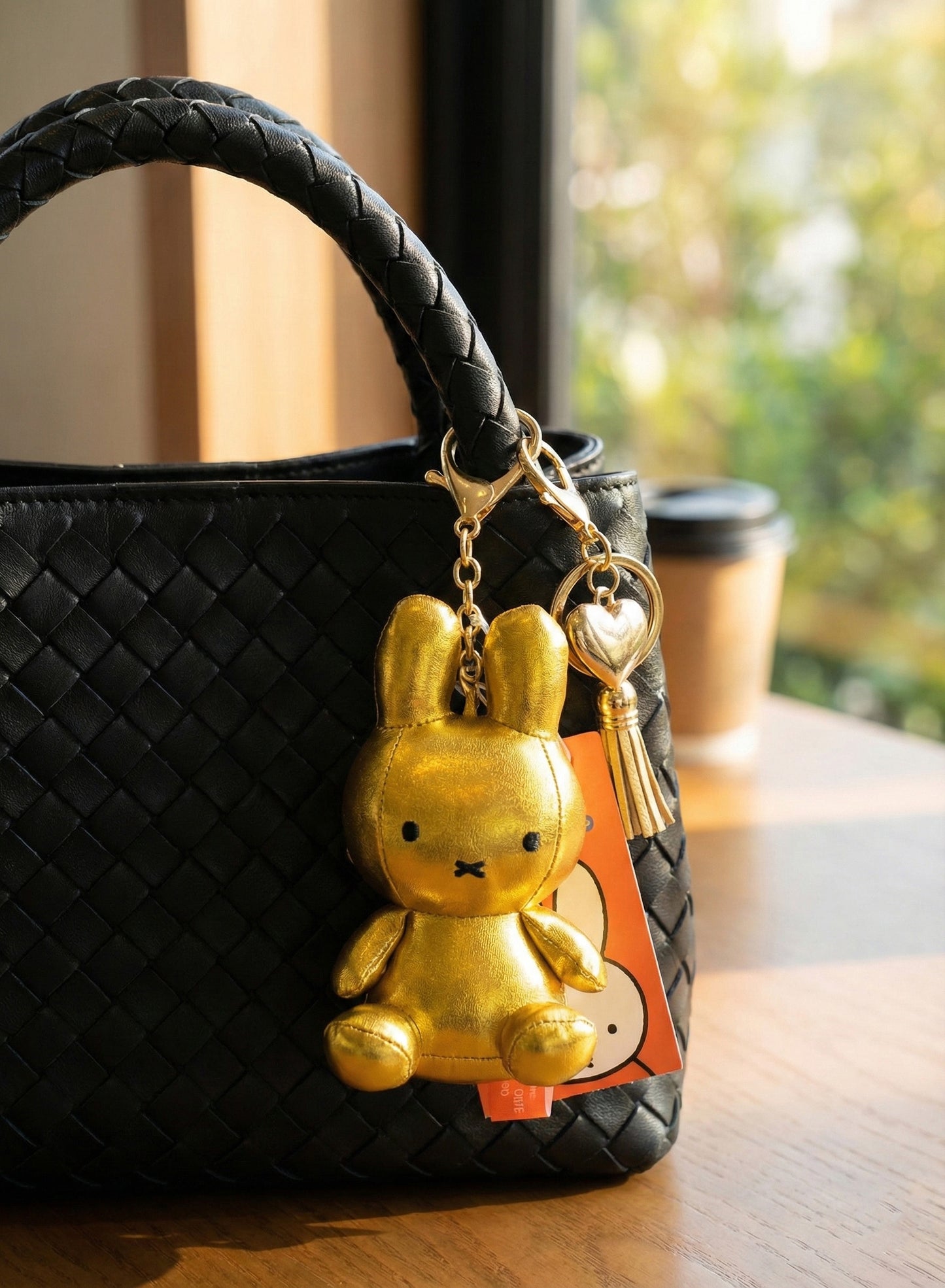 Gold metallic Miffy rabbit keychain on black leather designer bag - luxury bag charm