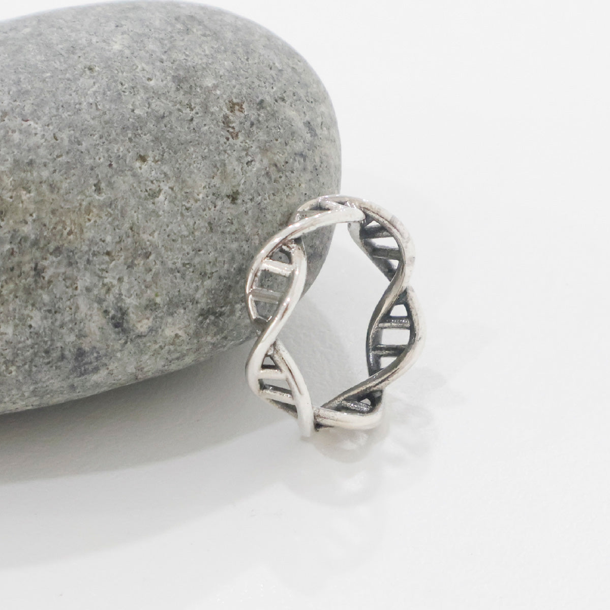 Detailed close-up of a sterling silver DNA helix ring with open ladder structure.
