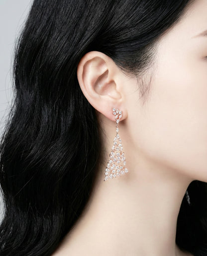 Close-up of rose gold chandelier earring detail on ear