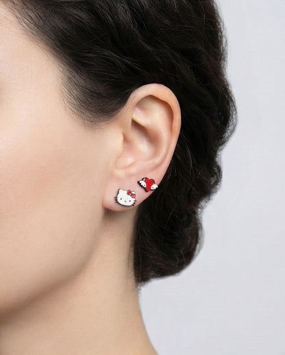 Woman wearing Hello Kitty and red heart wing enamel stud earrings, side angle showing cute Sanrio character design, 925 sterling silver posts hypoallergenic, Korean handmade jewelry