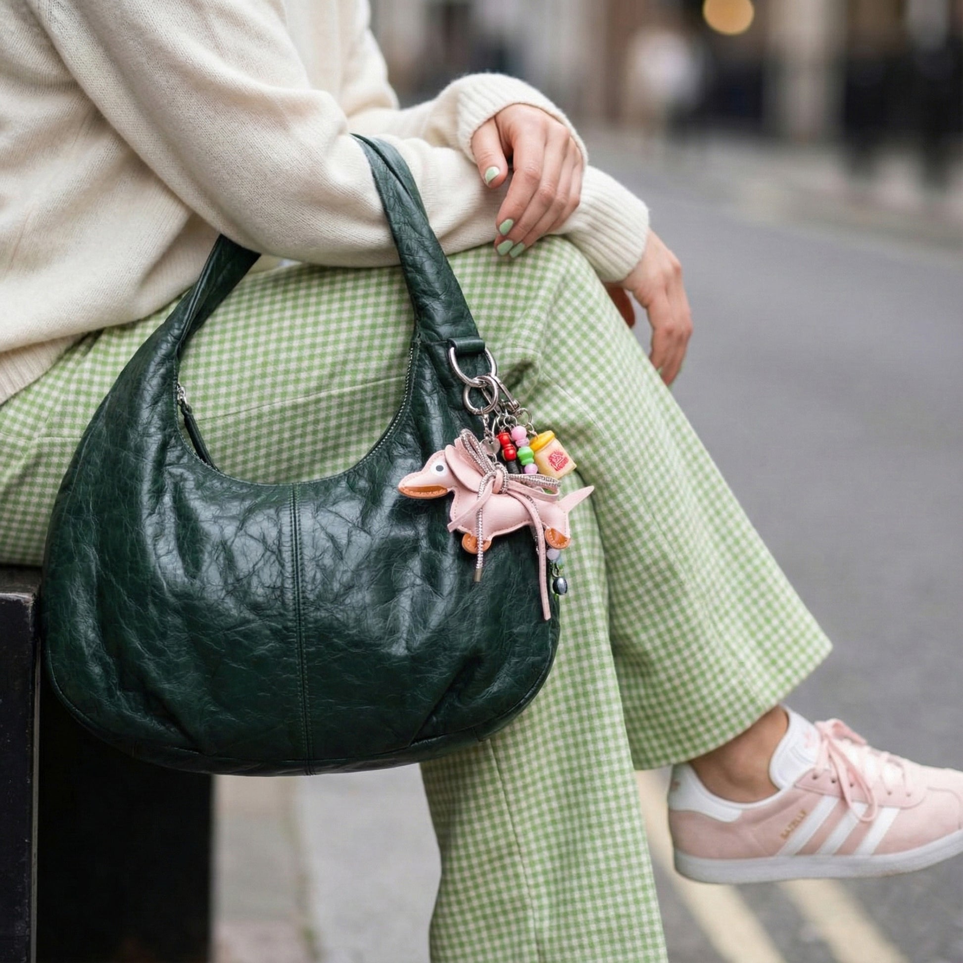 Pink leather Dachshund bag charm with sparkly bow accessory on green hobo bag coordinated with pastel fashion