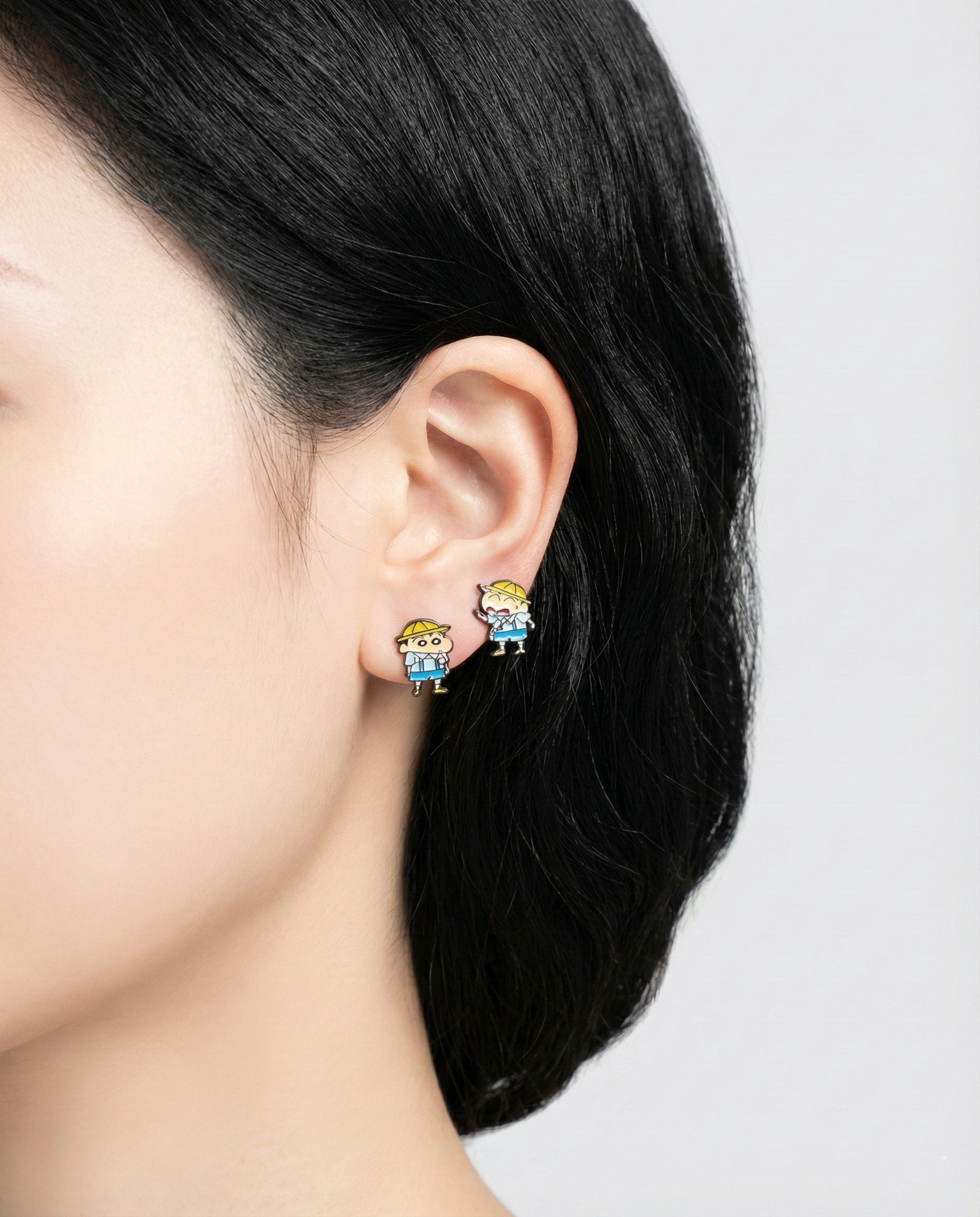 Model wearing asymmetrical Shin-chan and Max character stud earrings on left ear
