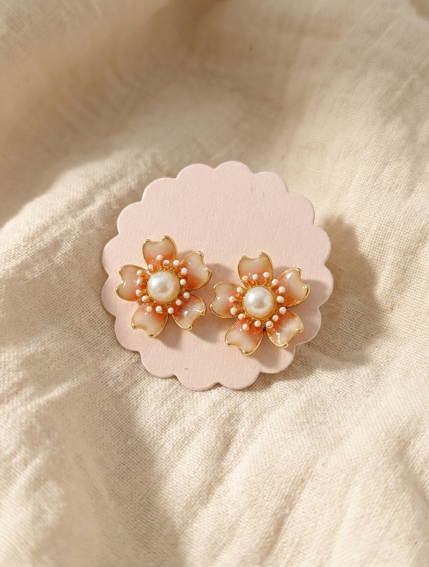  Peach coral flower earrings with gradient enamel finish and central pearl on pink scalloped display card