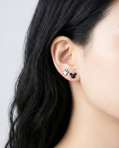 Model wearing Mickey white glove and black Mickey head stud earrings demonstrating layered ear styling