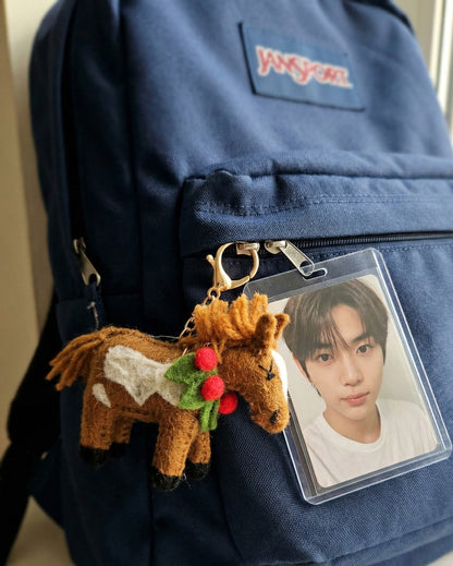 Brown felt horse keychain attached to navy JanSport backpack with K-pop idol photocard holder