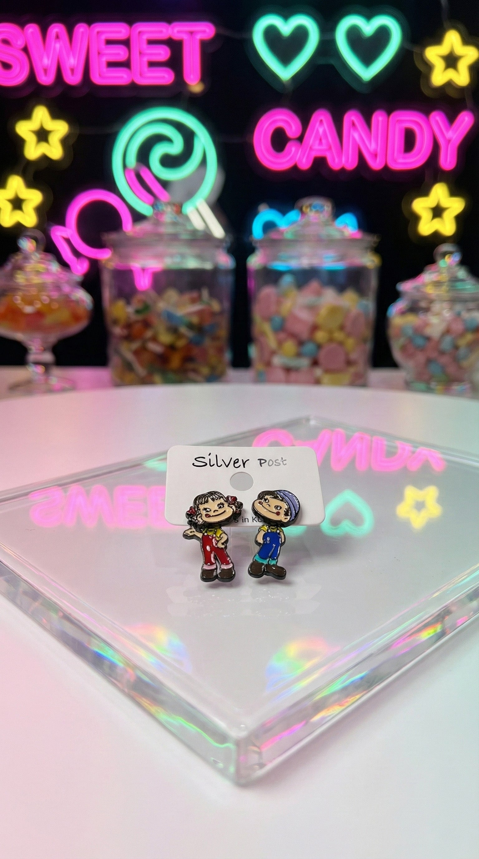 Y2K aesthetic Peko Poko earrings with sweet candy neon signs background