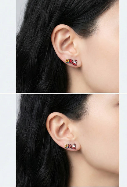 Model wearing mismatched Lotso Bear and Alien character earrings on earlobe