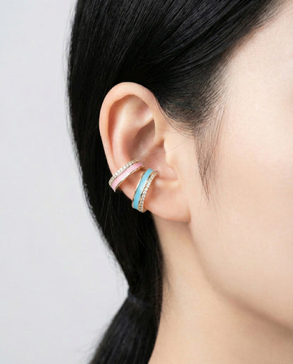 Turquoise and pink enamel ear cuffs with gold base and crystal detailing, stacked on helix