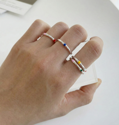 Hand shot showing three 925 silver enamel open rings worn on different fingers simultaneously, showcasing adjustable open band fit