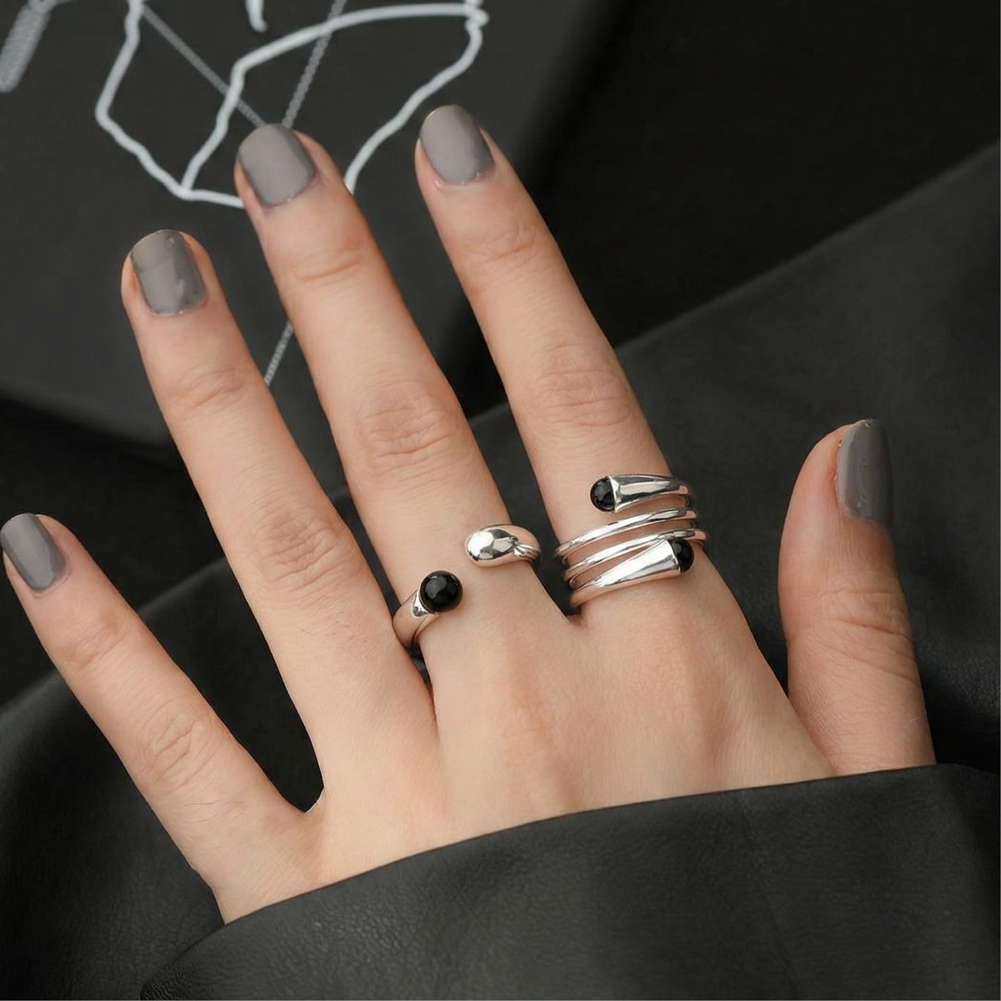 Model wearing 925 sterling silver single ring and spiral wrap ring together on both hands — black nail polish styling
