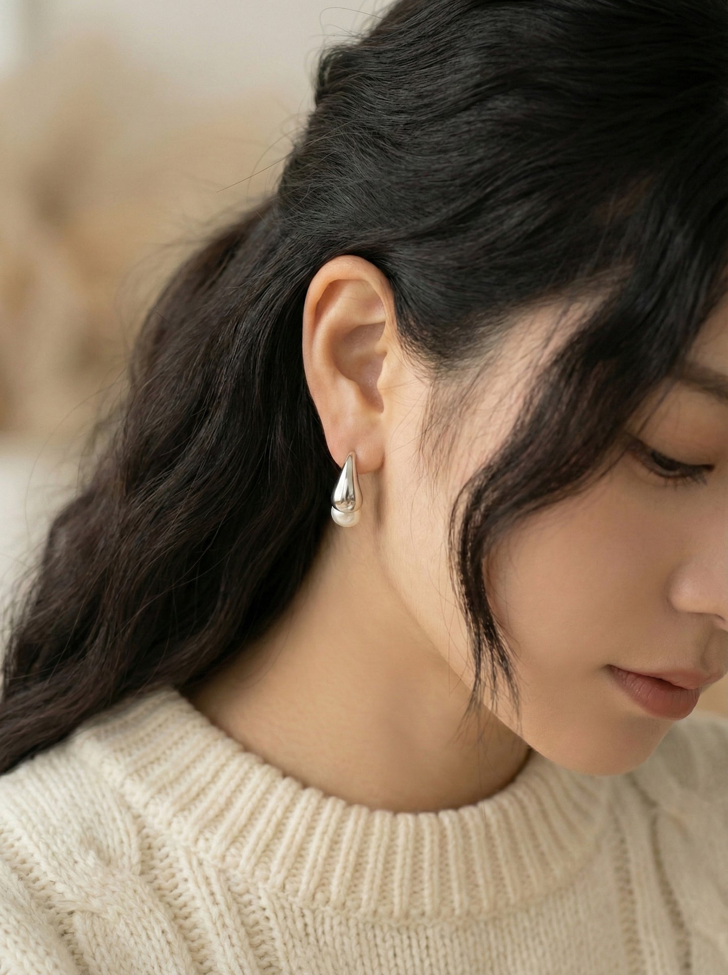  Model wearing silver teardrop pearl earrings elegant side angle with natural lighting