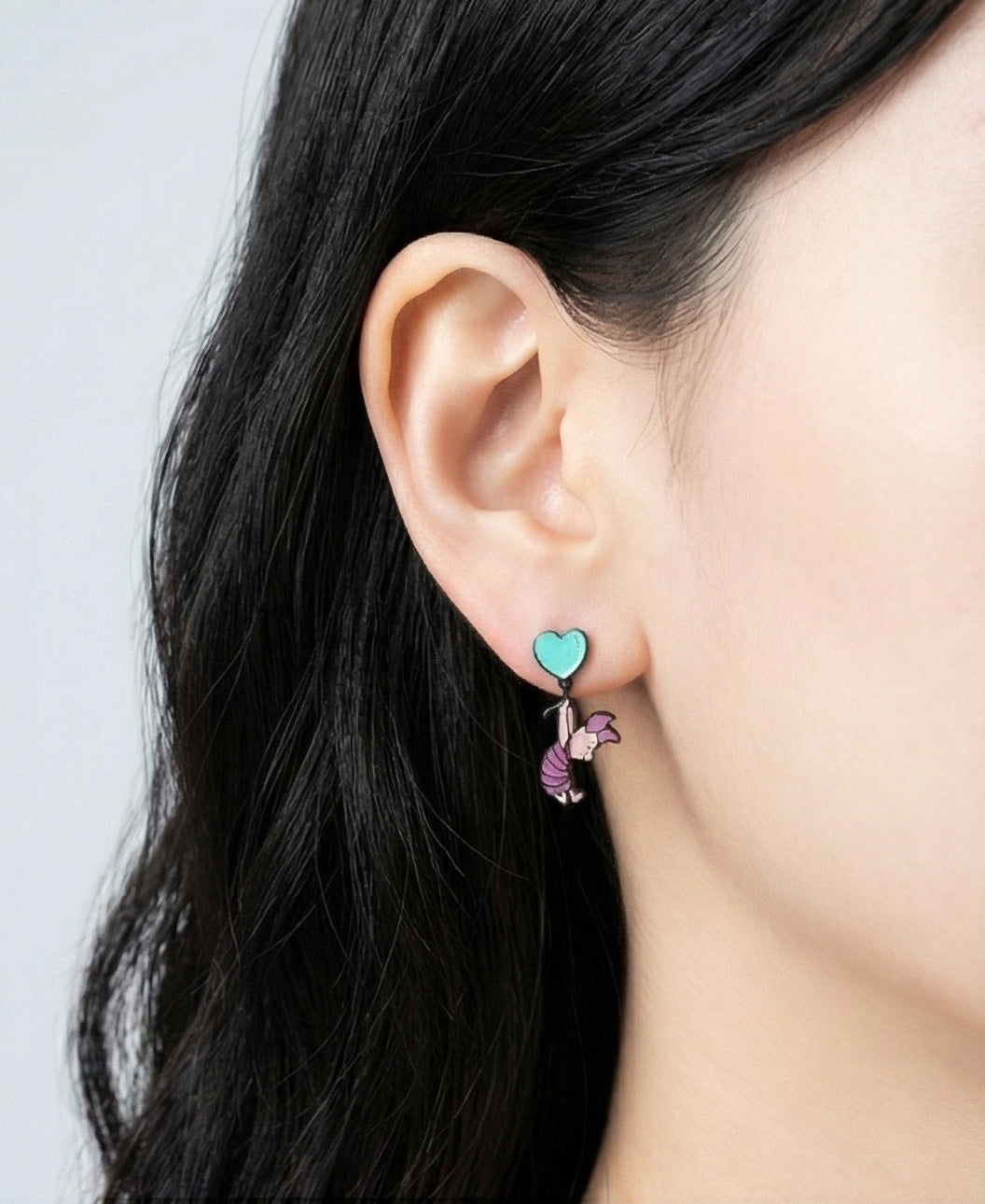 Turquoise balloon piglet earring styled on ear, whimsical drop design