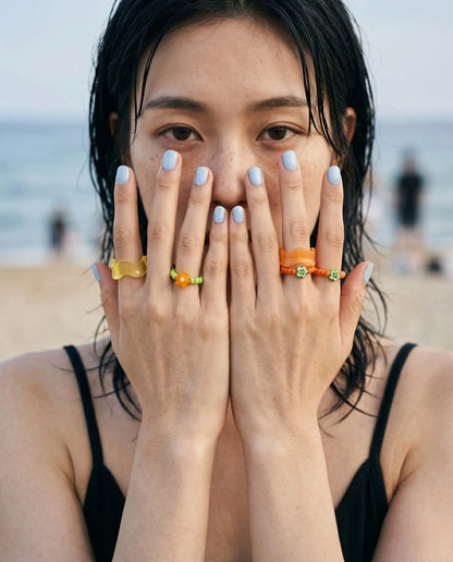 Both colorways of 8ttitto8 chunky resin wave ring and flower bead ring set styled with lavender nails, summer ring stack inspo for beach looks.