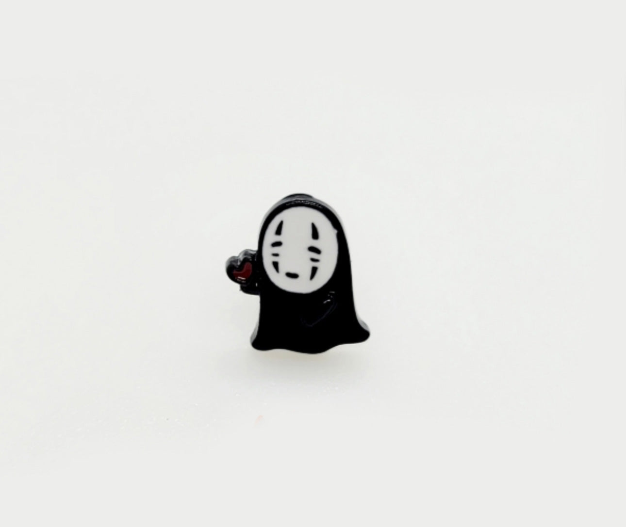 No-Face offering red heart stud earring, kawaii anime jewelry design.