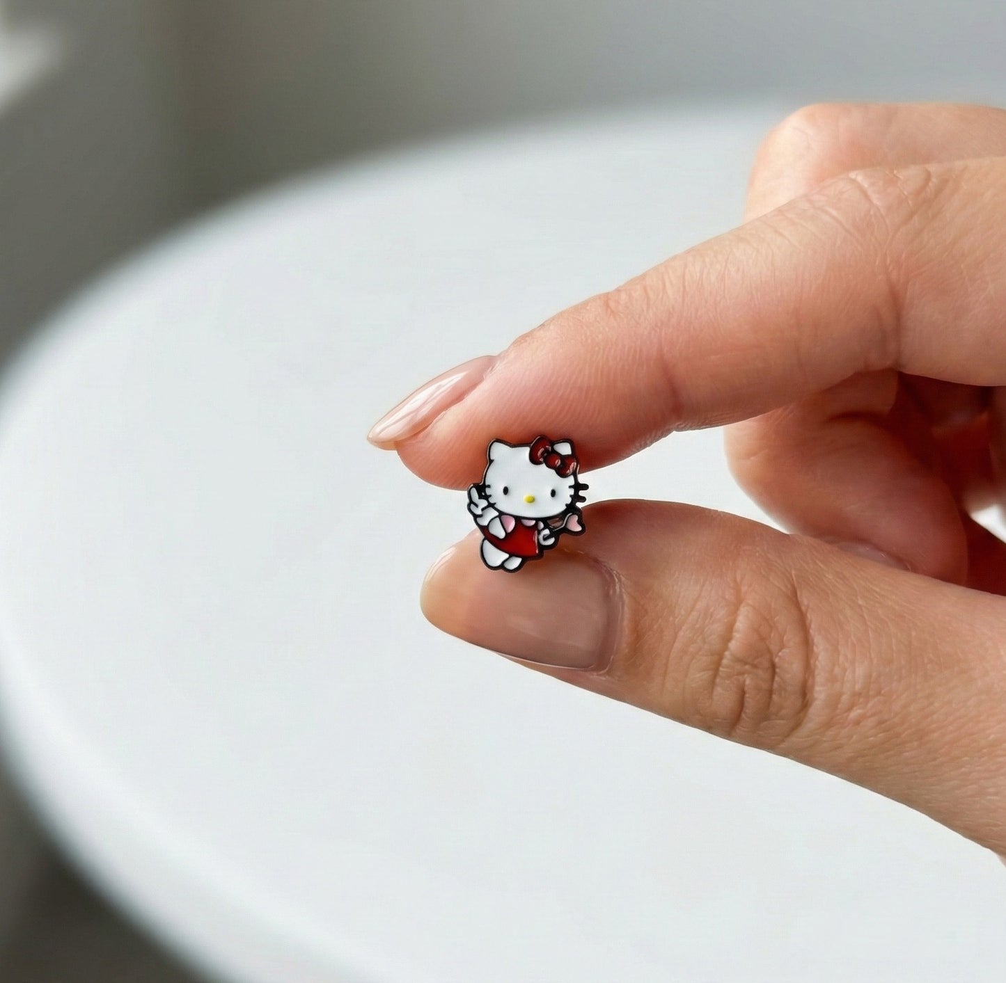 Close-up of Angel Cupid Hello Kitty stud showing detailed enamel work and glossy finish, handmade in Korea