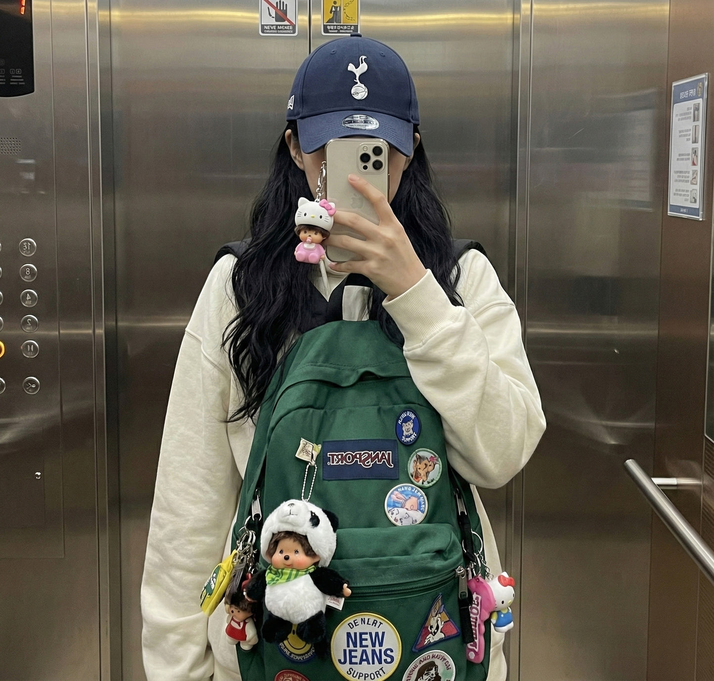 Elevator mirror selfie with panda Monchhichi keychain on decorated backpack
