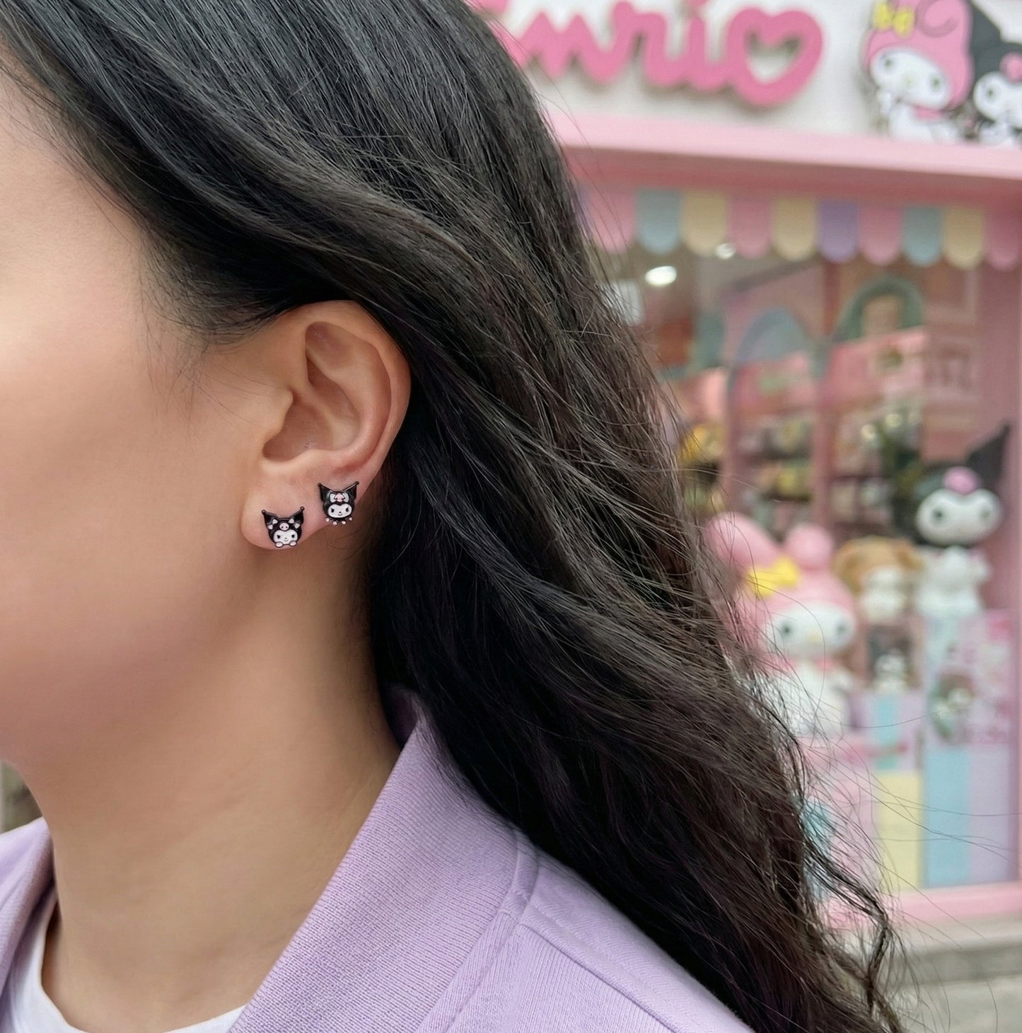 Model wearing Kuromi mismatched earrings with lavender purple sweater showing side profile