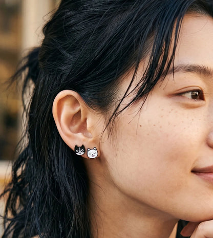 Black cat and white cat enamel stud earrings layered on one ear — cat mom jewelry, K-style curated ear, handmade in Korea