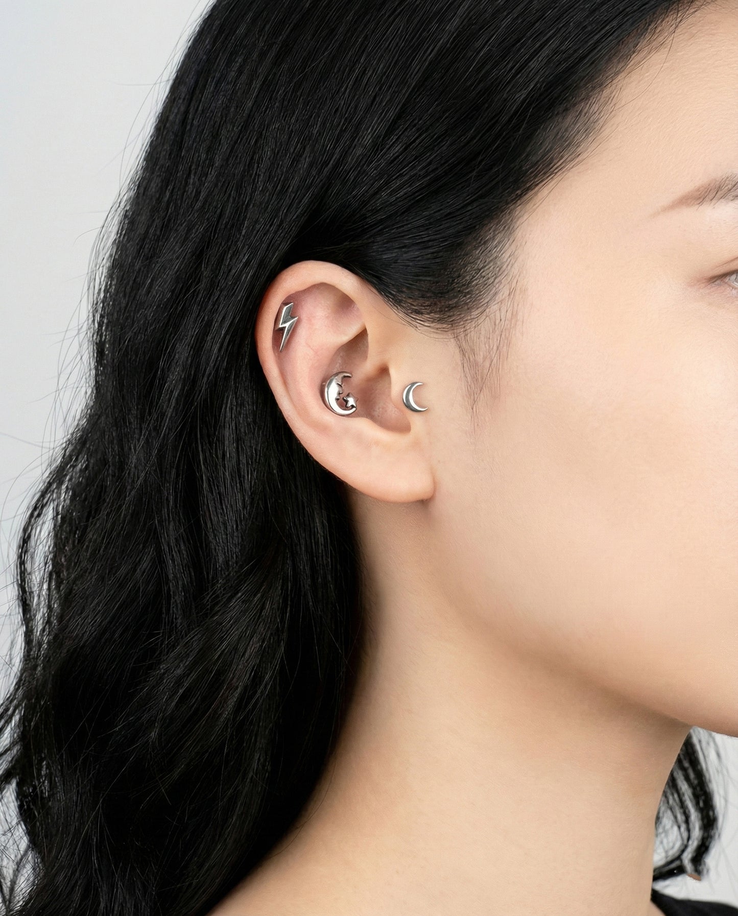 Antique silver moon and star piercing worn in conch with black turtleneck style