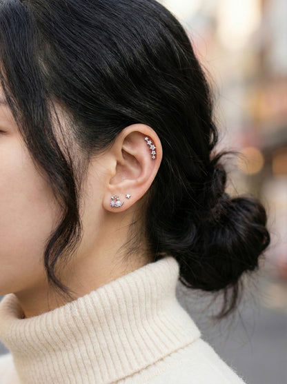 Multiple cartilage piercings styled together featuring moon rabbit earring with CZ line in helix