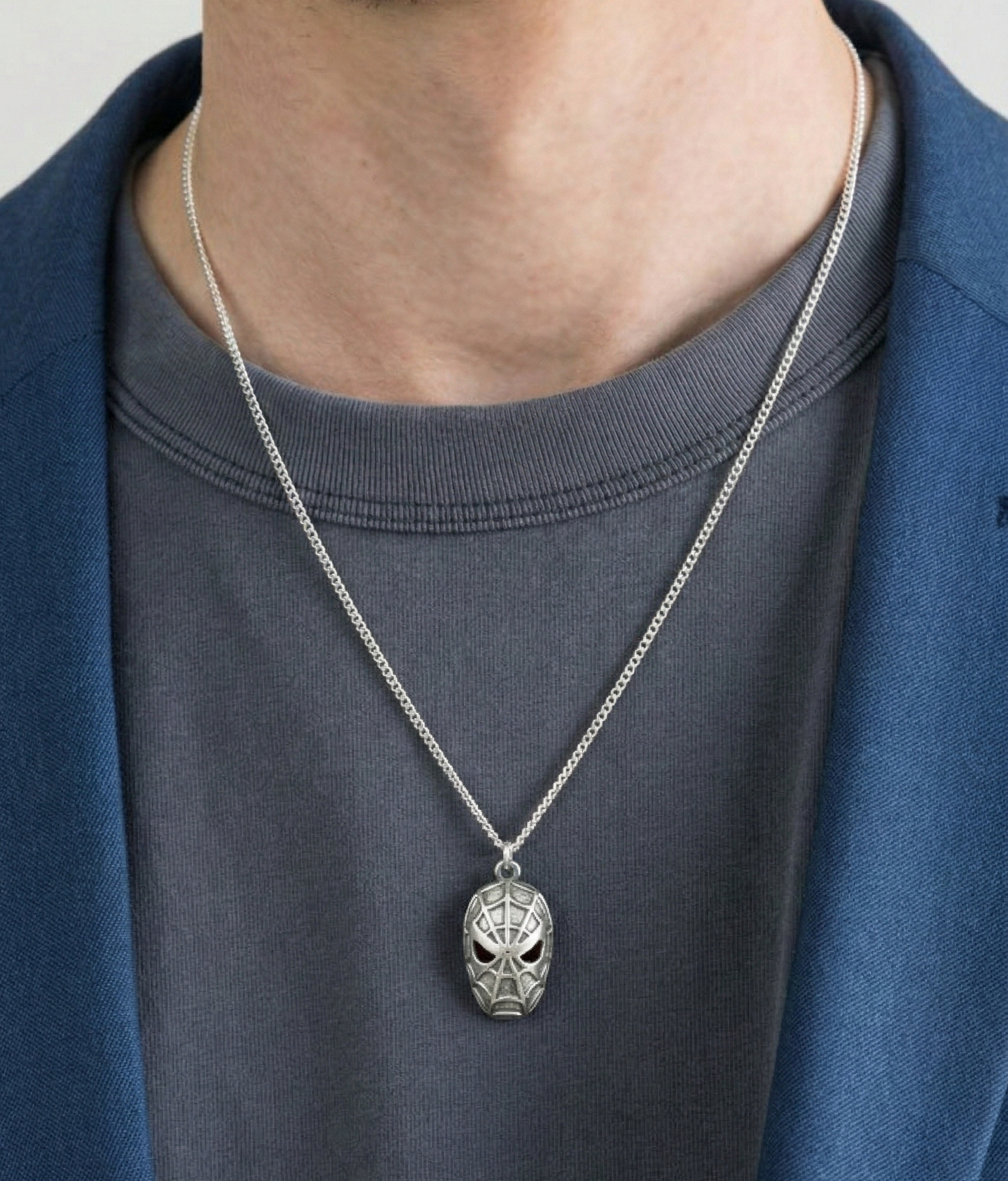 Man demonstrating the 55cm chain length with a silver spider pendant wearing a blue suit
