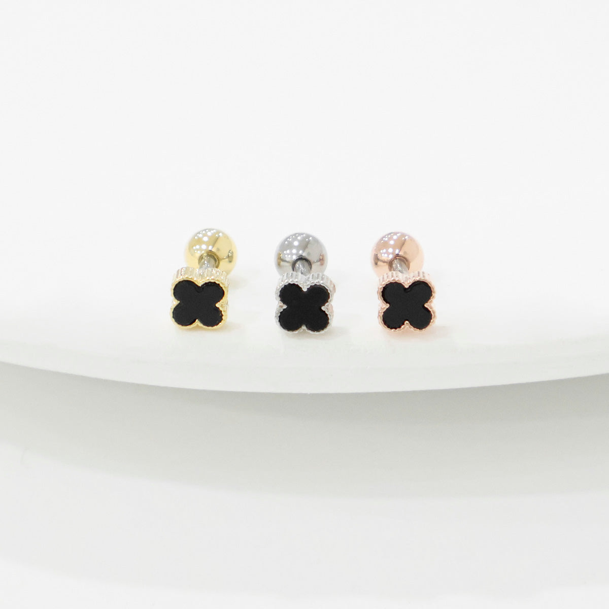 Four leaf clover mother of pearl piercing in black with gold silver rose gold titanium post on white background
