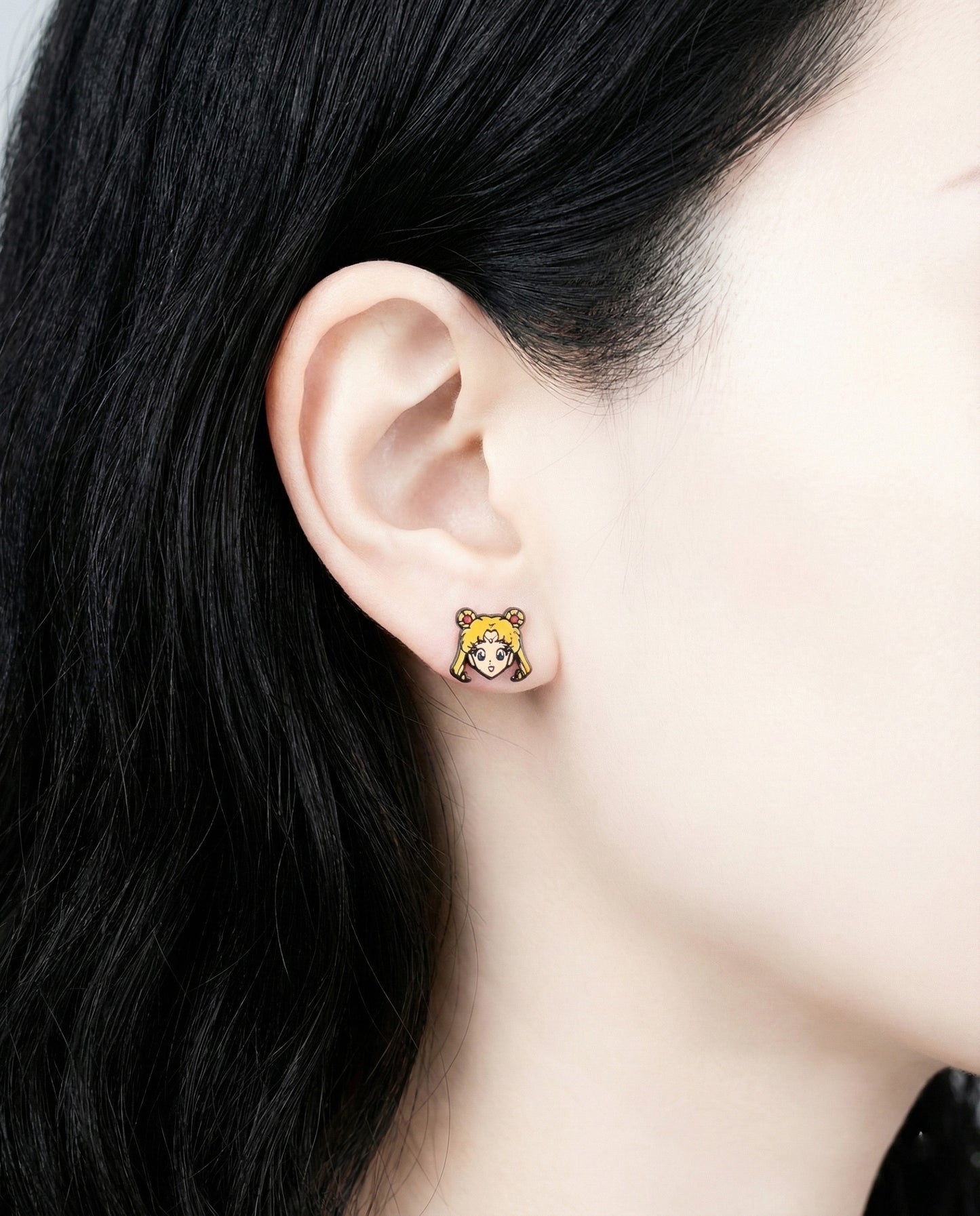Side view of model wearing Sailor Moon Usagi character enamel stud earring showing detail