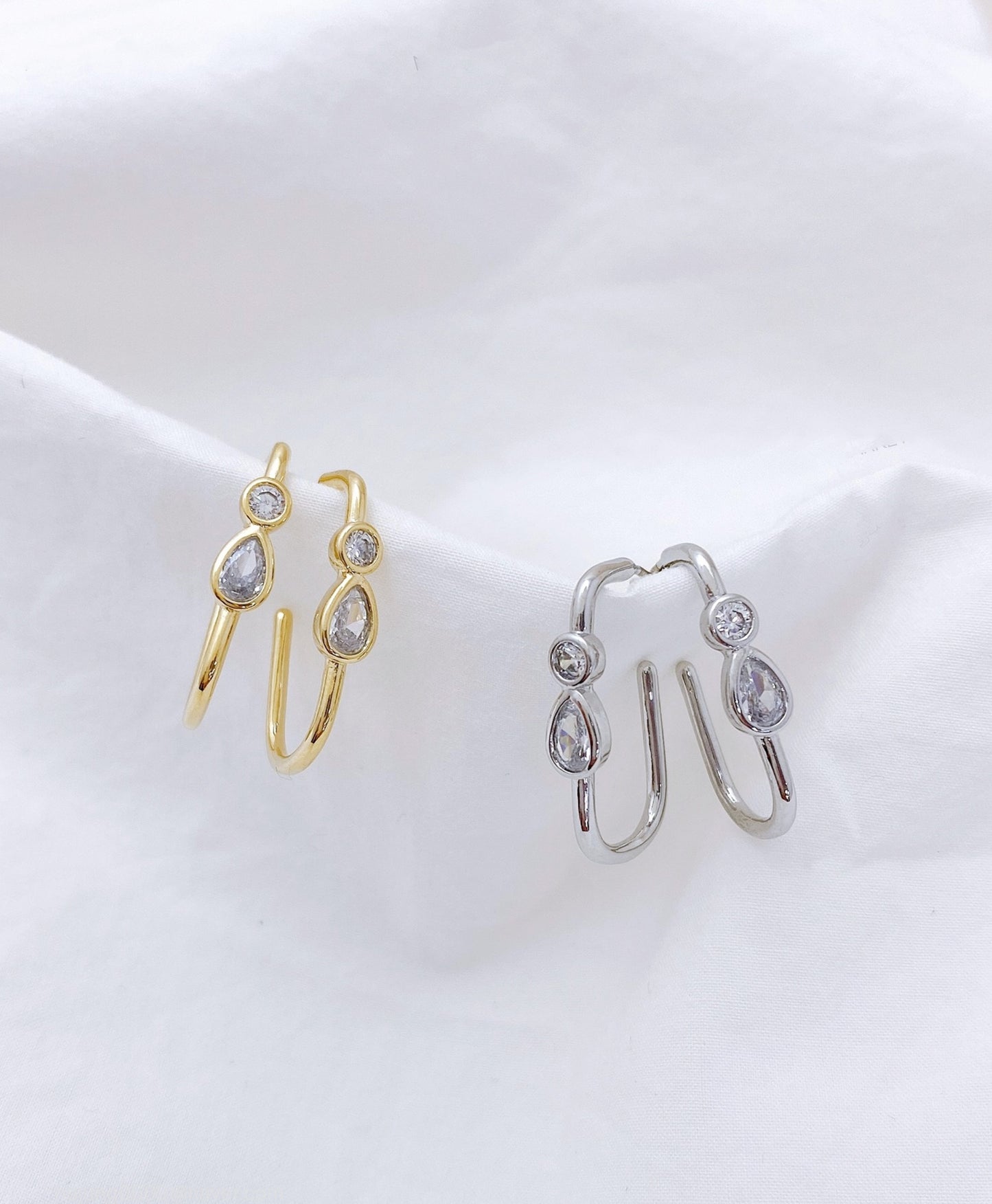 Gold and silver bezel-set U-shaped double cubic zirconia hoop earrings comparison on white background