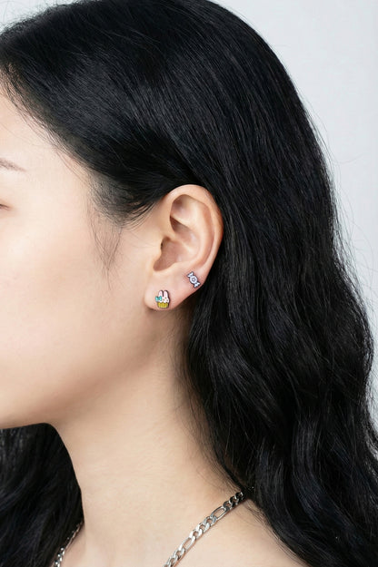 Side view of kawaii character earring set with cupcake and candy studs multiple piercings