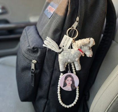  White wool felt pony keychain on black bag with idol photocard and pearl beaded chain accessory