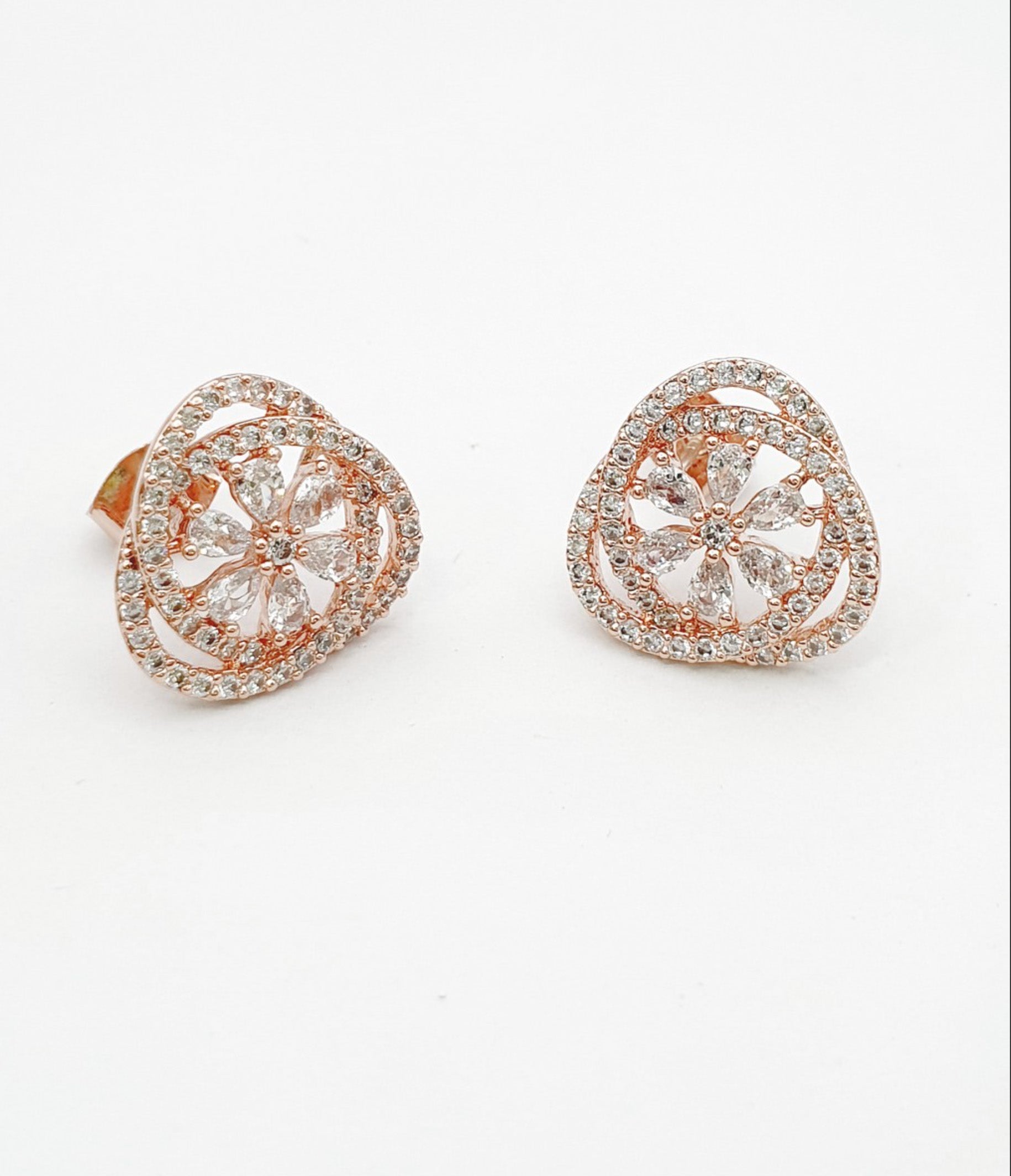 Pair of rose gold heart-shaped cubic zirconia stud earrings with flower motif center on white background, 925 sterling silver posts hypoallergenic