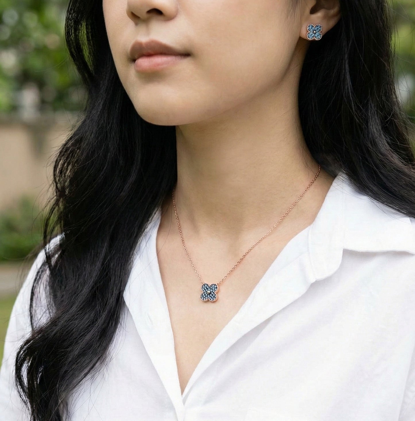 Matching blue clover necklace and earring set worn together, coordinated jewelry styling